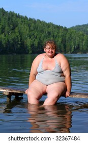 overweight woman sitting on stage in lake