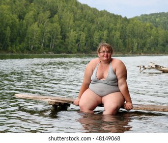 overweight woman sitting on stage in lake