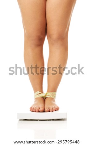 Overweight woman standing on a scale