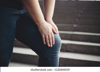 Overweight Woman Suffering From Knee Pain Stepping On Stairs. Excess Weight, Joint Overload, Health Care And Medical Concept