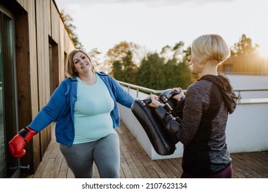 Overweight Woman Training Boxing With Personal Trainer Outdoors On Terrace.