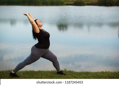 Overweight woman training near lake, copy space. Healthy lifestyle, sport, weight losing, activity concept