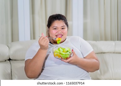 Overweight Woman Trying To Loose Weight By Eating Salad At Home