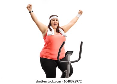 Overweight Woman Working Out On An Exercise Bicycle And Gesturing Happiness Isolated On White Background