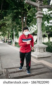 Overweight Young Asian Man Doing Jogging To Reduce Weight With Face Mask In Park