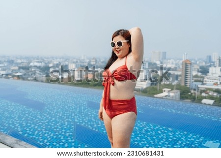 Overweight young asian woman wearing swimsuit relaxing in the pool Happy plus size woman cheery funny Vacation Traveling in summer
