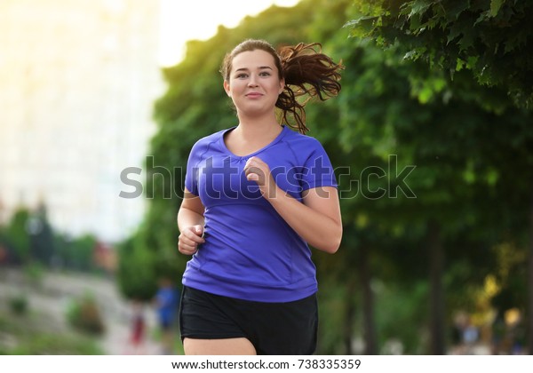 太り過ぎの若い女性が街でジョギングをしている 減量のコンセプト の写真素材 今すぐ編集