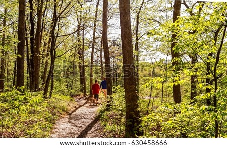 Overweight young woman and a young man taking a walk in the woods; Missouri State Park, Midwest