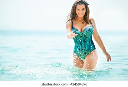 Overweight young woman in swimsuit near the sea. Size plus