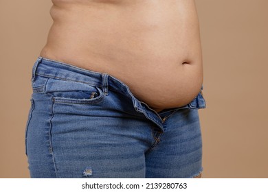 Overweighted plumpy lady with flabby stomach and fat sides showing waist in unzipped jeans. Sudden weight gain. Visceral fat. Body positive. Tight little clothes. Need for wardrobe change.