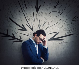 Overwhelmed businessman under pressure suffers headache and anxiety. High tension, dismay concept. Fatigue business person and multiple arrows points negativity towards him - Shutterstock ID 2120112491