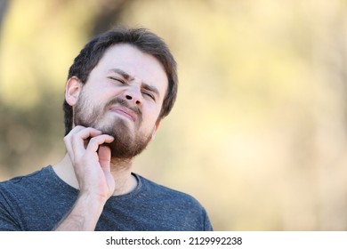 Overwhelmed Man Scratching Itchy Beard Outdoors