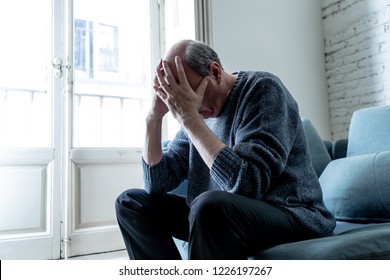 Overwhelmed old senior man suffering alone at home feeling confused sad alone on couch at home in Aging Retirement widower Dementia and Alzheimer concept. - Shutterstock ID 1226197267
