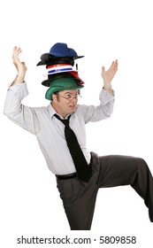 Overwhelmed White Collar Worker Wearing Too Many Hats And Balancing On One Foot.  Isolated On White.