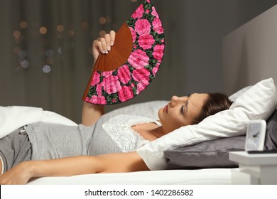 Overwhelmed Woman Fanning Suffering Heat Stroke Lying On The Bed In The Night At Home