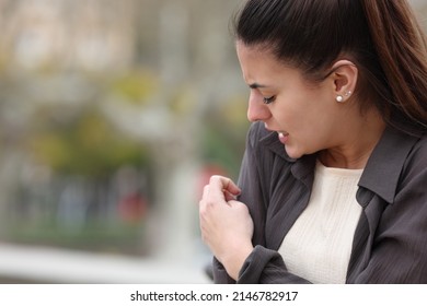 Overwhelmed Woman Scratching Arm In A Park