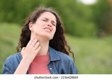 Overwhelmed Woman Scratching Itchy Neck Standing In A Park