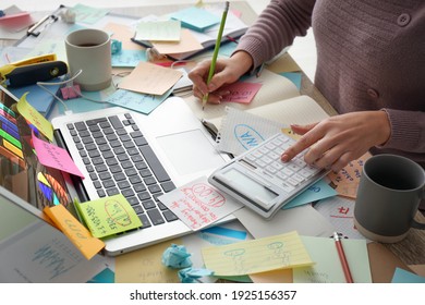 Overwhelmed woman working at messy office desk, closeup