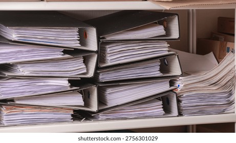 Overwhelming stack of paper document binder folder on office shelf ready for strict quality manual inspection to ensure accuracy
