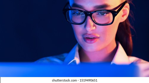 Overwork. Woman Working On Laptop, Face Illuminated By Blue Neon Light, Panorama