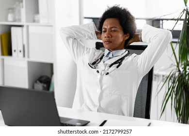Overworked Female African Doctor Sitting Pensively At Her Office