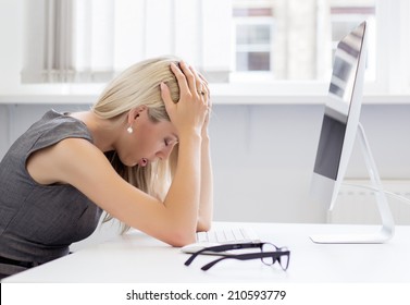 Overworked and frustrated young woman in front of computer