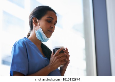 Overworked Nurse In Scrubs With Face Mask Takes Coffee Break In Busy Hospital During Health Pandemic