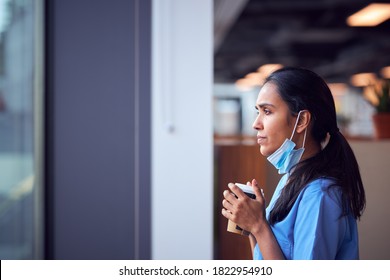 Overworked Nurse In Scrubs With Face Mask Takes Coffee Break In Busy Hospital During Health Pandemic