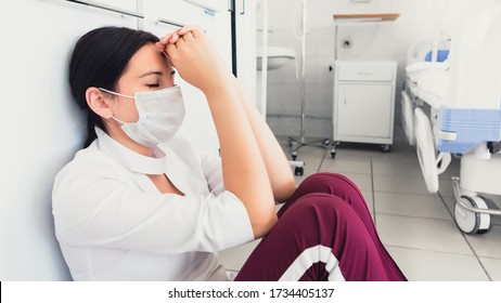 Overworked nurse sitting in hospital hallway. Tired after hard day medical staff in mask. Recession COVID-2019 - Shutterstock ID 1734405137
