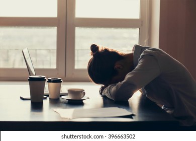 Overworked tired businesswoman sleeping on table in office. Young exhausted girl working from home. Woman using laptop. Entrepreneur, business, freelance work, student, stress, work from home concept