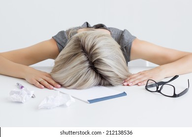 Overworked and tired young woman sleeping on desk