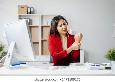 Overworked young Asian businesswoman office worker suffering from neck pain after had a long day at her office desk. office syndrome concept - Powered by Shutterstock