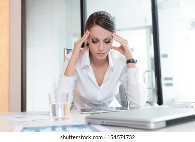 Overworking Business Woman Suffering From Headache 