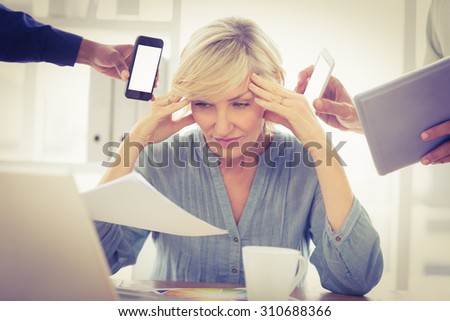 Overwrought businesswoman with hands on head at the office