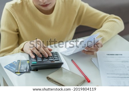 Owe, problem asian woman, female broke sitting on floor at home stressed and confused by calculate expense from invoice or bill, no money pay, mortgage or loan. Debt, bankruptcy or bankrupt concept.