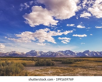 Owens River runs though Arid plains against Sierra Nevada Mountains and dramatic sky in the Owens River Valley near Mammoth Lakes