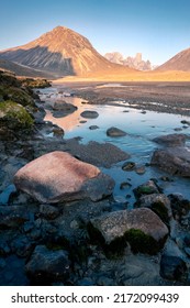 Owl River bed near Mt. Asgard, Akshayuk Pass, Nunavut. Beautiful arctic landscape in the early, sunny morning. Iconic mountains on distant horizon. Wild north.