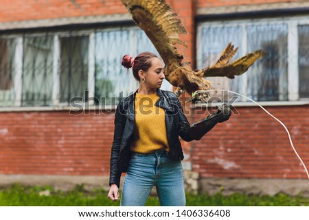 The owl sits on the girl's hand. The woman with the owl.