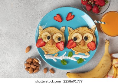 Owl-shaped pancakes with strawberries, bananas and almonds, a creative breakfast for kids or Valentine's Day, Copy space - Shutterstock ID 2258691779