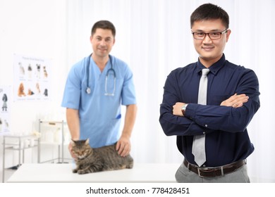 Owner Of Business And Staff With Cat In Veterinary Hospital