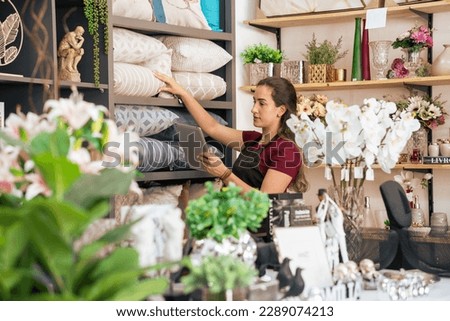 Owner checks products and stock in home decor store