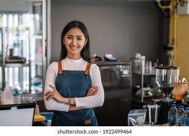 Owner Of A Coffee Shop, An Asian Woman, Smiling And Waiting To Serve Customers At The Coffee Shop. Looking Camera.