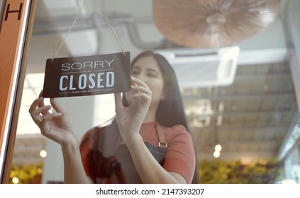 Owner Coffee Shop Woman Hand Flip The Sign To Closed The Shop.closed Sign Hanging On The Glass Door.