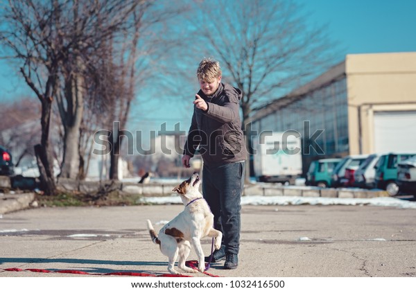 The owner of the dog went out in the parking\
lot to play with him, the dog is happy and playful with his master,\
the puppy wants to jump the\
master