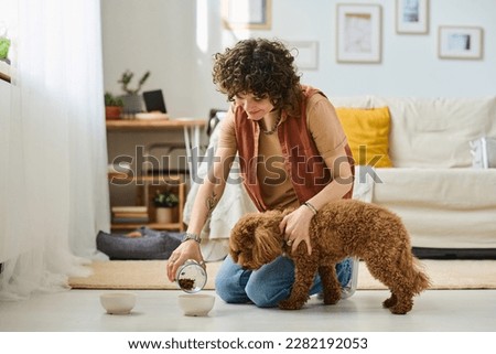 Owner feeding her pet at home