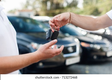The owner of a new car getting the keys from the hands of the car dealer - Shutterstock ID 713272468