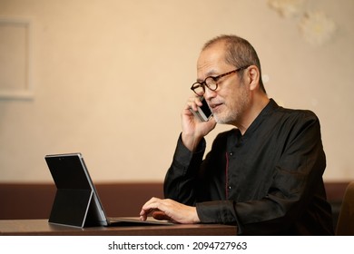 The Owner Of A Restaurant Who Makes A Phone Call While Looking At A Computer