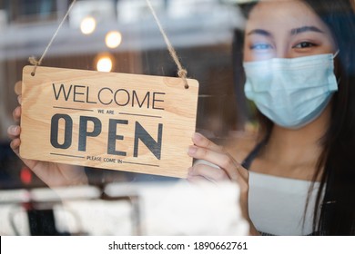 Owner Retail,coffee Shop Woman Turning Sign Board To Open With Wearing Face Mask ,protection To Pandemic Of Coronavirus Reopen Store,restaurant After Close Lockdown Quarantine In Covid To New Normal.