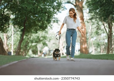 Owner walking with dog together in park outdoors, summer vacation, Adorable domestic pet concept, Friendship between human and their pet - Shutterstock ID 2350774743