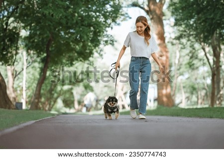 Owner walking with dog together in park outdoors, summer vacation, Adorable domestic pet concept, Friendship between human and their pet